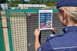 Na zdjęciu mundurowa podczas przyczepiania plakatu z zasadami bezpieczeństwa na terenie skateparku