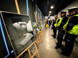 galeria zdjęć i oglądający je umundurowani policjanci