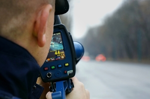 policjant drogówki mierzy prędkość urządzeniem laserowym trucam