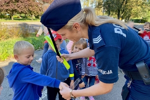 na zdjęciu policjantka uczy przedszkolaków przechodzenia przez jezdnię