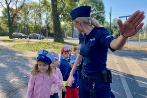 na zdjęciu policjantka uczy przedszkolaków przechodzenia przez jezdnię