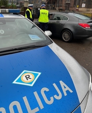 policjanci wykonujący kontrolę drogową