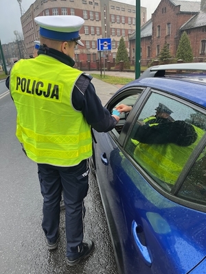 policjant wręczający odblask kierowcy