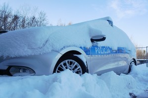 Zdjęcie przedstawia zaśnieżony radiowóz