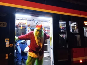 maskotka Grinch w drzwiach tramwaju