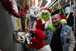 Mężczyzna robiący zdjęcie z maskotkami Królik Bugs i Grinch