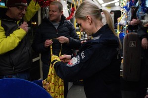 policjantka rozdająca smycze z napisem alkohol stop