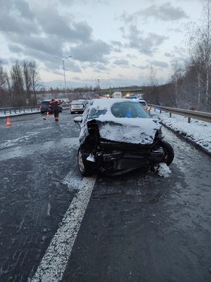 zdjęcie przedstawia rozbity samochód osobowy i wykonujące czynności na drodze służby