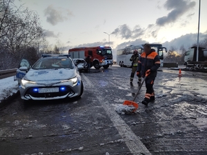 zdjęcie przedstawia rozbity samochód osobowy i wykonujące czynności na drodze służby