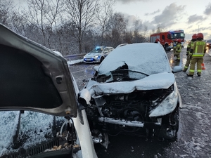 zdjęcie przedstawia rozbity samochód osobowy i wykonujące czynności na drodze służby