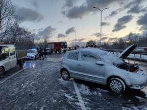 zdjęcie przedstawia rozbity samochód osobowy i wykonujące czynności na drodze służby