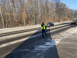 policjantka ruchu drogowego unosząca rękę do góry na znak zatrzymania pojazdu