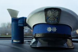 zdjęcie przedstawia czapkę policyjną i urządzenie do badania trzeźwości