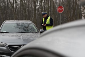 zdjęcie przedstawia policjanta podczas kontroli drogowej