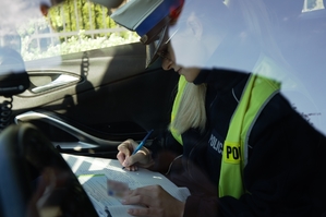 zdjęcie przedstawia: policjantka ruchu drogowego sporządzająca dokumentację