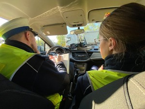 zdjęcie przedstawia: policjanci ruchu drogowego sporządzający dokumentację w radiowozie
