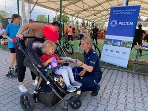 zdjęcie przedstawia: policjantkę wręczającą odblask dziecku