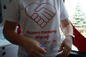 zdjęcie przedstawia: zbliżenie na koszulkę z napisem &quot;razem możemy więcej&quot;