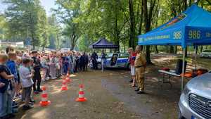 dzieci słuchające funkcjonariusza straży miejskiej i straży pożarnej