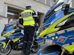 zdjęcie przedstawia: policjanta stojącego obok policyjnego motocykla