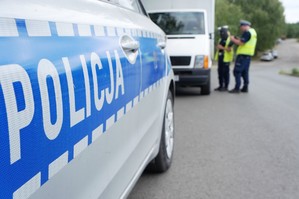 zdjęcie przedstawia policjantów stojących przy samochodzie