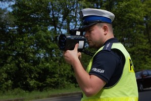 zdjęcie przedstawia policjanta mierzącego prędkość