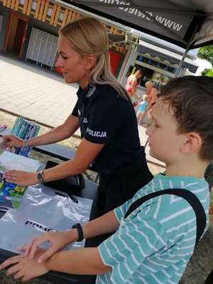 zdjęcie przedstawia policjantkę na stoisku profilaktycznym