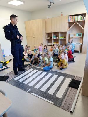 zdjęcie przedstawia policjanta w przedszkolu podczas prelekcji