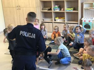 zdjęcie przedstawia policjanta w przedszkolu podczas prelekcji