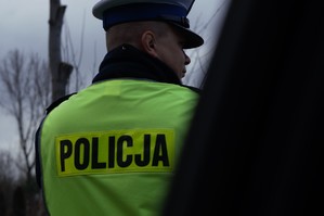 zdjęcie przedstawia policjanta ruchu drogowego w kamizelce z napisem policja