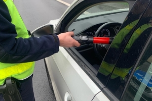 zdjęcie przedstawia policjanta badającego trzeźwość