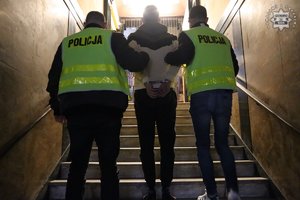 policjanci trzymają zatrzymanego mężczyznę