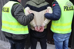 policjanci trzymają zatrzymanego mężczyznę