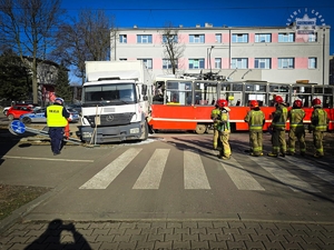 zdjęcie przedstawia policjanta i strażaków na miejscu wypadku drogowego z udziałem tramwaju