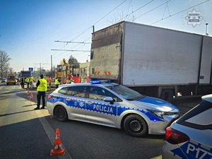 zdjęcie przedstawia policjanta i strażaków na miejscu wypadku drogowego z udziałem tramwaju