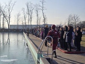 zdjęcie przedstawia strażaków podczas pokazu ratownictwa lodowego i dzieci stojące przy basenie