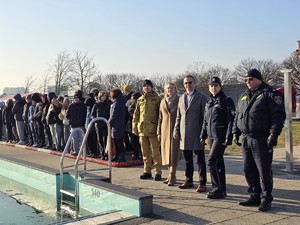 zdjęcie przedstawia przedstawicieli służb i dzieci stojące przy basenie