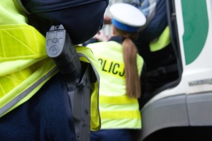 zdjęcie przedstawia zbliżenie na broń a w tle policjantkę