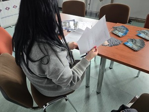 zdjęcie przedstawia kobietę wypełniającą dokumenty