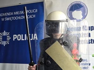 osoba w stroju policjanta z tarczą i hełmem
