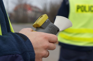 zdjęcie przedstawia policjanta trzymającego urządzenie do badania trzeźwości