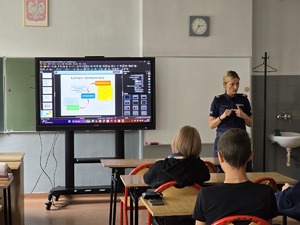 zdjęcie przedstawia policjantkę rozmawiającą z uczniami