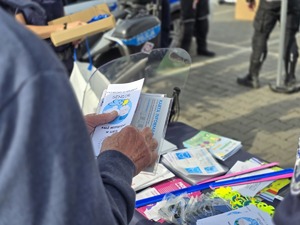 zdjęcie przedstawia mężczyznę trzymającego ulotki informacyjne