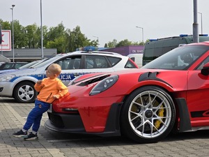zdjęcie przedstawia zbliżenie na chłopca i samochód sportowy