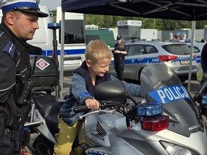 zdjęcie przedstawia chłopca siedzącego na policyjnym motocyklu