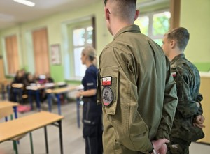zdjęcie przedstawia mundurowych rozmawiających z uczniami klas ósmych