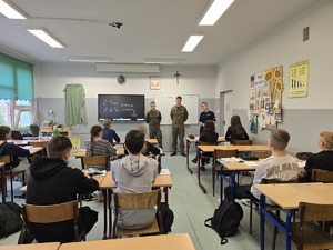 zdjęcie przedstawia mundurowych rozmawiających z uczniami klas ósmych