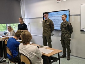 zdjęcie przedstawia mundurowych rozmawiających z uczniami klas ósmych