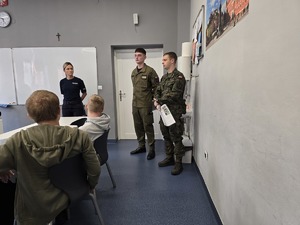 zdjęcie przedstawia mundurowych rozmawiających z uczniami klas ósmych