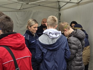 zdjęcie przedstawia policjantkę i uczestników festynu przy stoisku policjantów